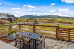 Enjoy outdoor living with this spacious patio featuring a dining set and a beautiful planter box.