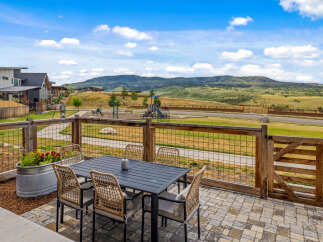Enjoy outdoor living with this spacious patio featuring a dining set and a beautiful planter box.