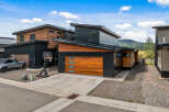 Experience modern living in this stunning home featuring a sleek, dark exterior contrasted with warm wood accents.