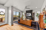 Experience modern living in this stunning living room featuring a sleek fireplace and expansive windows with breathtaking views.