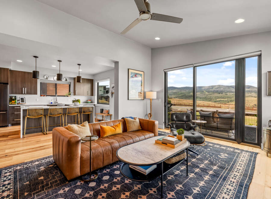 Experience modern living with this stunning open-concept space, featuring a sleek kitchen with a breakfast bar and a comfortable living area.
