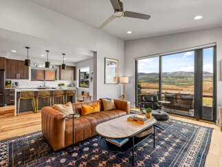 Experience modern living with this stunning open-concept space, featuring a sleek kitchen with a breakfast bar and a comfortable living area.