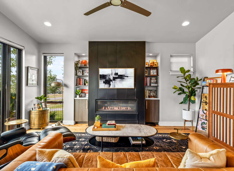 Experience modern living in this stunning living room featuring a sleek gas fireplace as the focal point, complemented by built-in shelving for a sophisticated display.