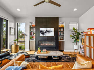 Experience modern living in this stunning living room featuring a sleek gas fireplace as the focal point, complemented by built-in shelving for a sophisticated display.