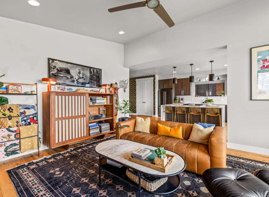 Experience modern living in this stylish open-concept space, featuring a sleek leather sofa and a marble-topped coffee table perfect for entertaining.