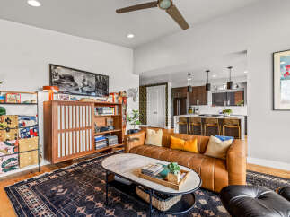 Experience modern living in this stylish open-concept space, featuring a sleek leather sofa and a marble-topped coffee table perfect for entertaining.