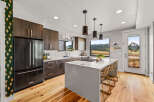 Experience modern living in this stunning kitchen featuring dark wood cabinetry and a sleek white quartz island.