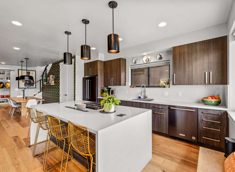 Experience modern living in this stunning kitchen featuring a large island with bar seating, perfect for entertaining.