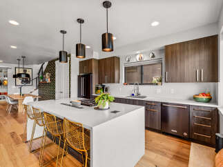 Experience modern living in this stunning kitchen featuring a large island with bar seating, perfect for entertaining.