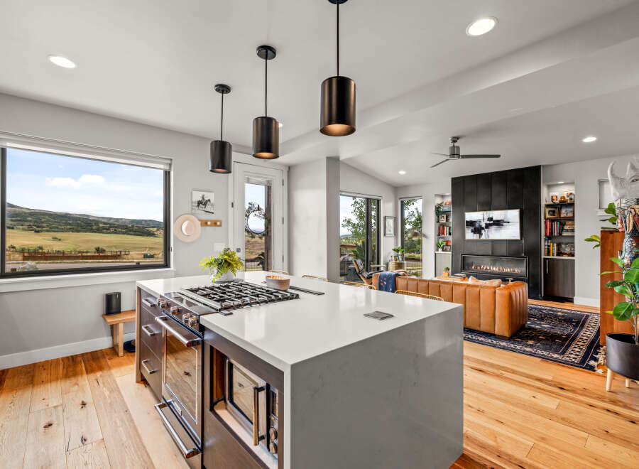 Experience modern living in this stunning open-concept home, featuring a gourmet kitchen with a large island and a sleek gas range.