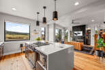 Experience modern living in this stunning open-concept home, featuring a gourmet kitchen with a large island and a sleek gas range.