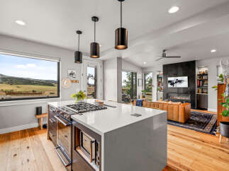 Experience modern living in this stunning open-concept home, featuring a gourmet kitchen with a large island and a sleek gas range.