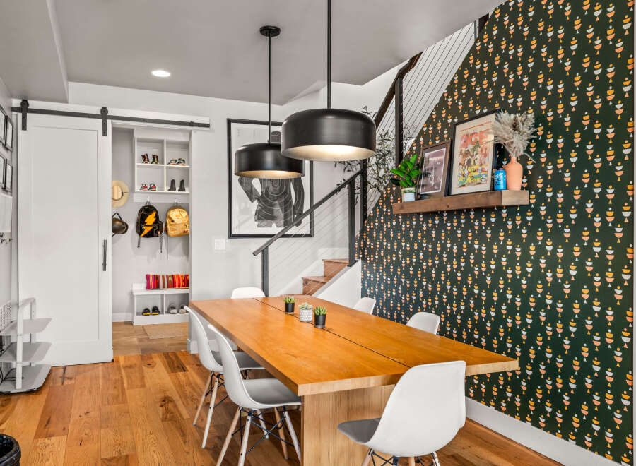 This dining area boasts a modern aesthetic with a large wooden table and white chairs, perfect for family gatherings.