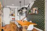 This dining area boasts a modern aesthetic with a large wooden table and white chairs, perfect for family gatherings.
