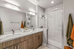 Experience modern luxury in this stunning bathroom featuring a spacious double vanity with sleek cabinetry and a bright, airy walk-in shower.