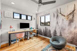 This modern home office features a large wooden desk with a mounted TV, perfect for productivity and entertainment.