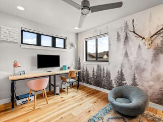 This modern home office features a large wooden desk with a mounted TV, perfect for productivity and entertainment.