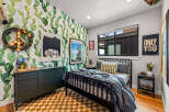 This vibrant bedroom features a playful cactus-themed wallpaper that adds a unique personality to the space.