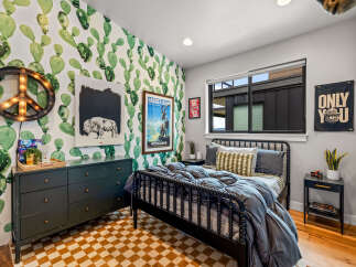 This vibrant bedroom features a playful cactus-themed wallpaper that adds a unique personality to the space.