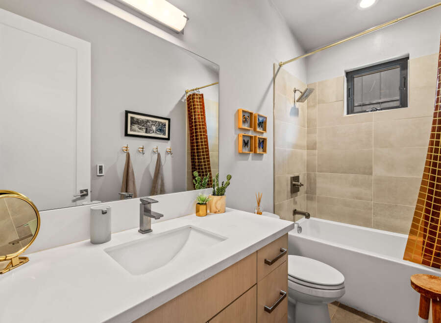 This modern bathroom features a sleek vanity with a vessel sink and a contemporary faucet, complemented by a large vanity mirror.