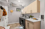 This laundry room offers ample storage with overhead cabinets and a convenient countertop space.