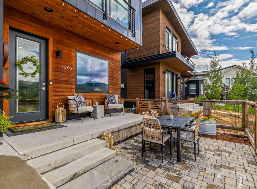 Experience modern living in this stunning home featuring a warm wood exterior and a welcoming front porch.