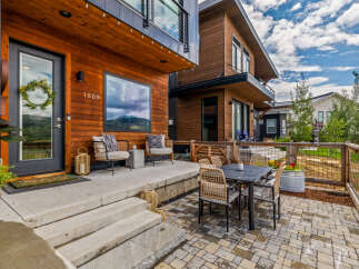 Experience modern living in this stunning home featuring a warm wood exterior and a welcoming front porch.