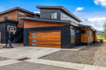 Experience modern living in this stunning home featuring a sleek black metal exterior complemented by warm wood accents.