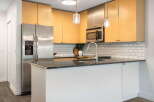 This modern kitchen boasts sleek stainless steel appliances, including a side-by-side refrigerator and a built-in microwave.