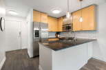 Discover this charming kitchen featuring sleek stainless steel appliances, including a side-by-side refrigerator and a built-in microwave.