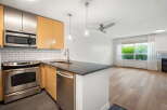 Discover this modern kitchen featuring stainless steel appliances, including a microwave and oven, complemented by sleek cabinetry and a granite countertop.