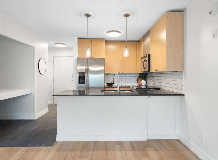 Discover this modern kitchen featuring sleek granite countertops and a convenient island perfect for meal prep or casual dining.