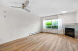 Experience modern living in this spacious room featuring a sleek ceiling fan and a cozy gas fireplace.
