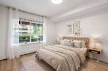 Experience serene living in this beautifully appointed bedroom, featuring a plush bed with a woven headboard and a cozy, textured throw.