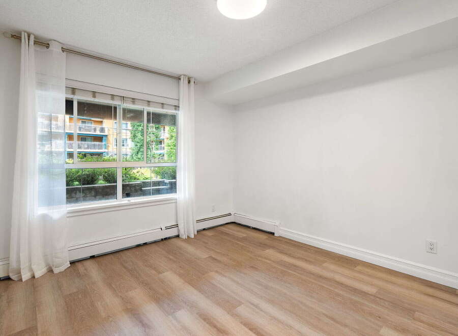 Bright and airy, this room features a large window with sheer curtains, offering ample natural light.