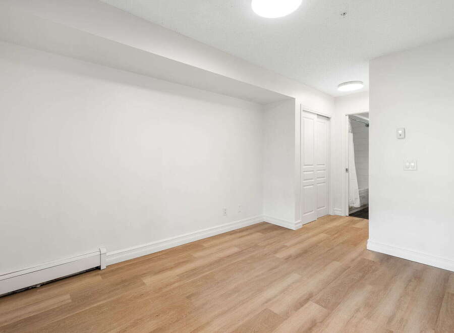 Discover this bright and airy living space featuring a clean, modern aesthetic with crisp white walls and elegant light wood flooring.