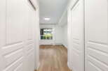 Step into this bright and airy hallway, featuring pristine white doors that lead to spacious rooms.