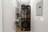 This laundry room features a sleek, black Samsung stacked washer and dryer unit, perfect for maximizing space.