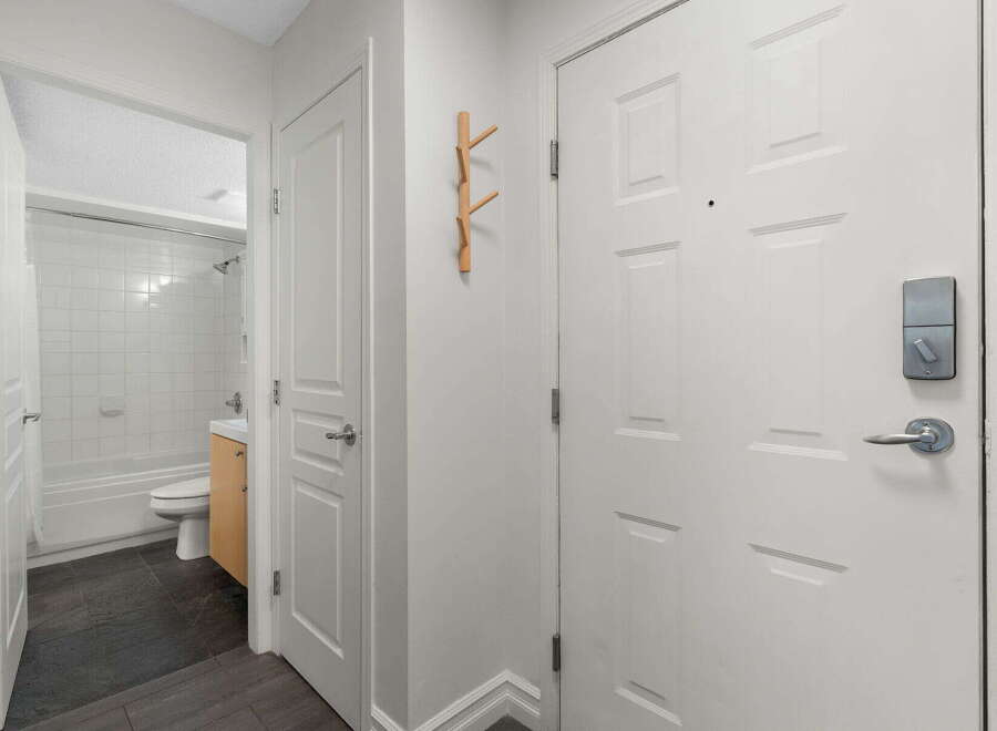 Step into this inviting entryway featuring a sleek smart lock on the front door for enhanced security.