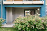 Enhance your curb appeal with this charming property featuring a welcoming entrance adorned with lush, blooming bushes.
