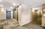 Step into this inviting hallway featuring a modern elevator and a stylish, geometric carpet pattern.