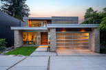 Experience modern luxury in this stunning home featuring a sleek design with stone accents and a frosted glass garage door.