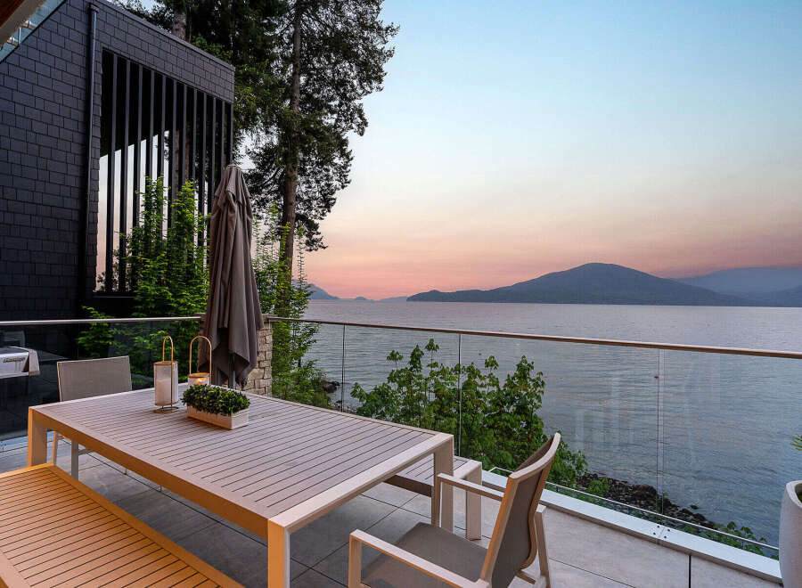 Experience breathtaking sunset views from this modern home's expansive outdoor living space.