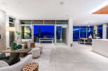 Experience luxurious modern living in this stunning open-concept home, featuring a spacious living area that seamlessly flows into a dining space and an outdoor patio.