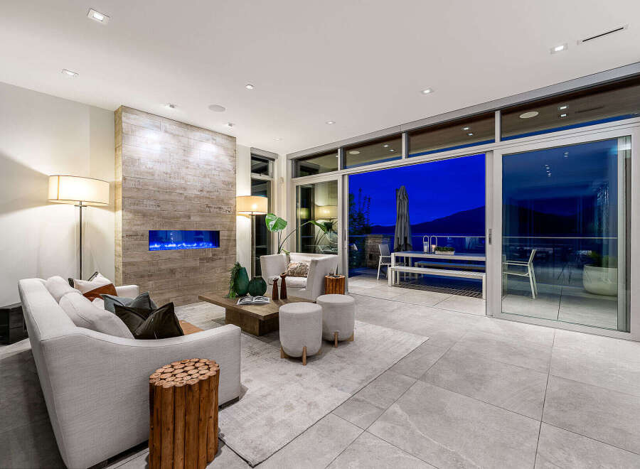 Experience luxurious living in this modern home featuring a stunning fireplace with blue flames and a spacious open-concept living area.