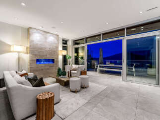 Experience luxurious living in this modern home featuring a stunning fireplace with blue flames and a spacious open-concept living area.