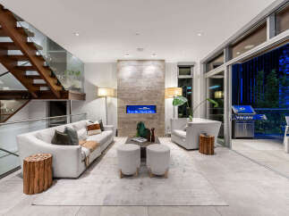 Experience modern luxury in this stunning living room, featuring a sleek fireplace with a blue flame and a striking wood-paneled accent wall.