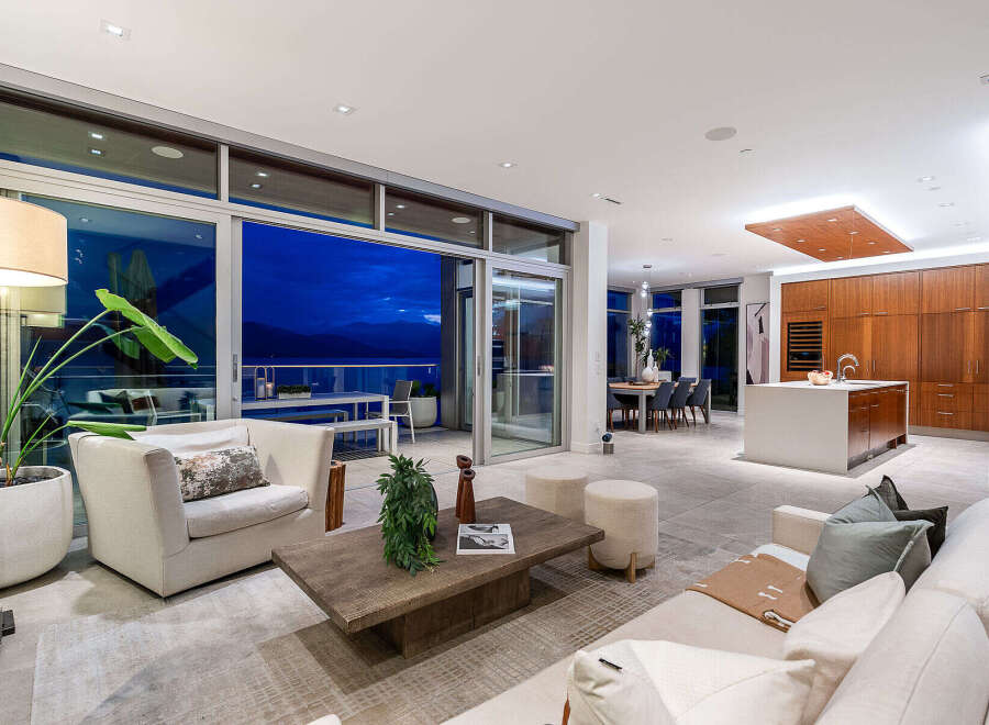 Experience luxurious modern living in this stunning open-concept space, featuring a gourmet kitchen with a large island and ample custom cabinetry.
