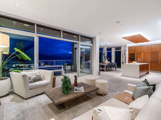 Experience luxurious modern living in this stunning open-concept space, featuring a gourmet kitchen with a large island and ample custom cabinetry.