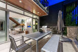 Experience seamless indoor-outdoor living with this stunning patio featuring a modern dining set and a built-in grill.